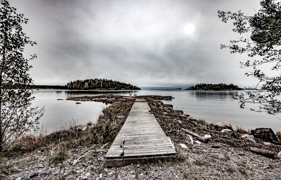 Slightly twisted lake pier laying on dry land during a gloomy overcast day.